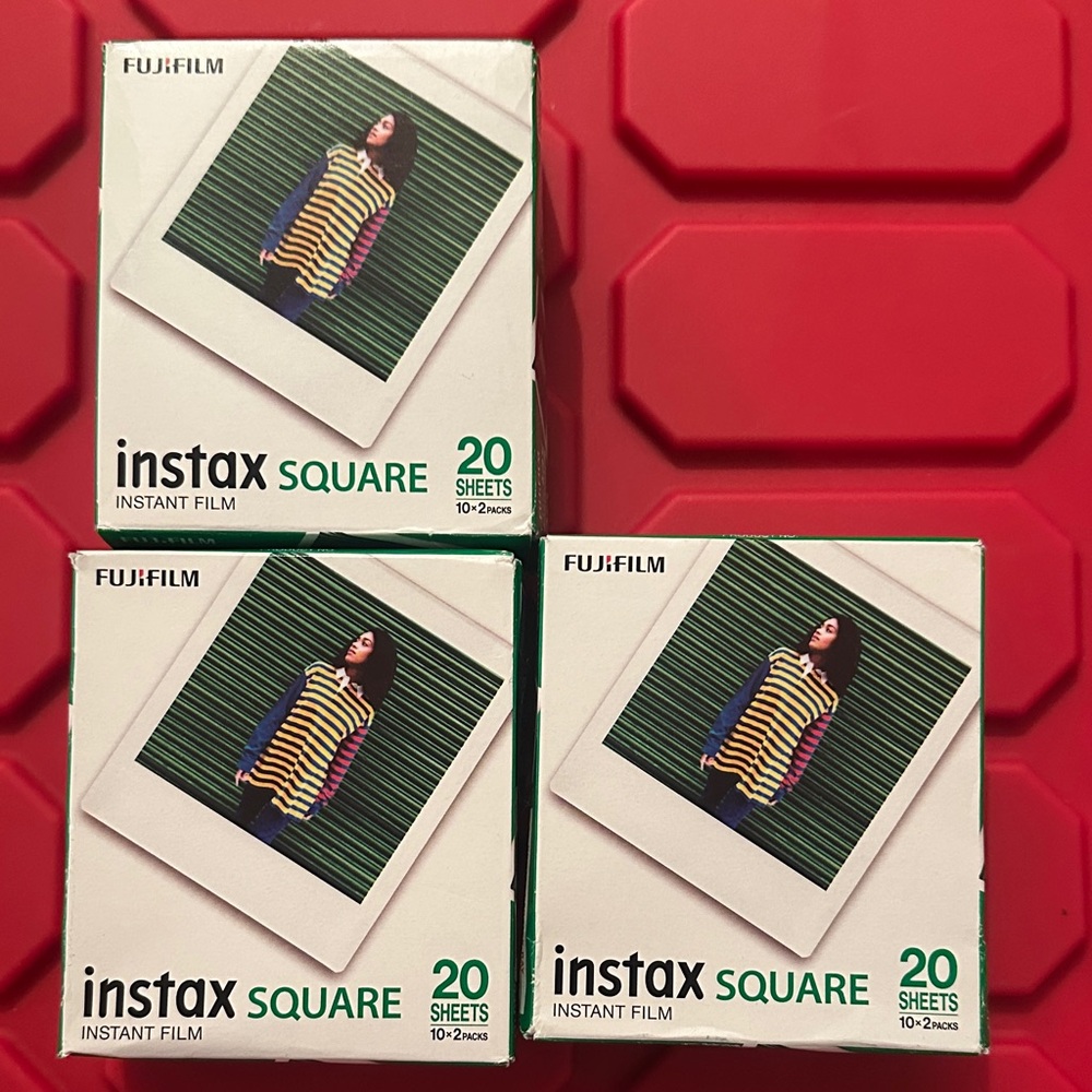 Fujifilm Instax SQUARE Instant Film Boxes with White Borders on Red Surface